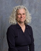 Image of Lauri Krouse sitting in front of a grey background.