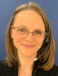 Image of Danielle Meder wearing glasses smiling at the camera with a blue background.