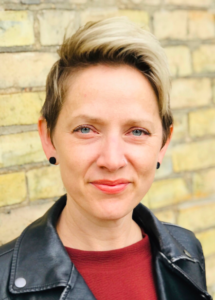 Image of Melissa Lund standing in front of a brick wall.